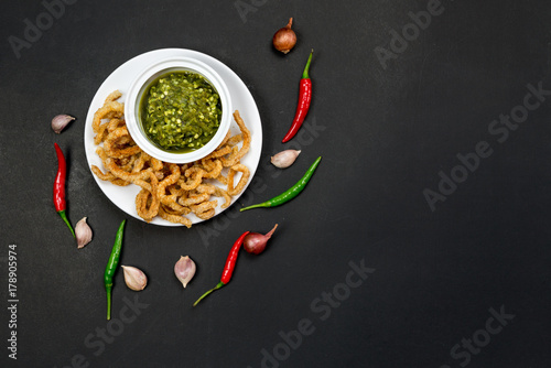 Northern thai green chili dip or call in thai is "Nam Prik Num" food of thai tradition eat with pork rind or fresh vegetables , on banana leaf background include copyspace for add text or graphic