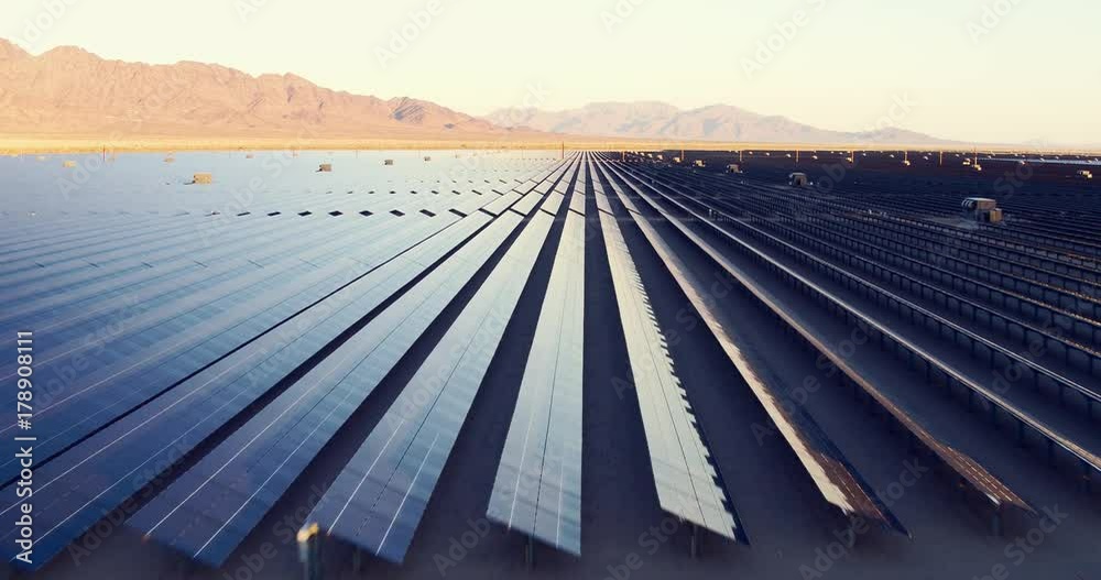 Aerial shot over solar panels in desert sun
