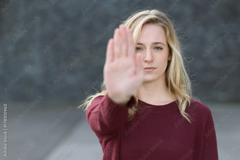 Stern young woman making a stop gesture