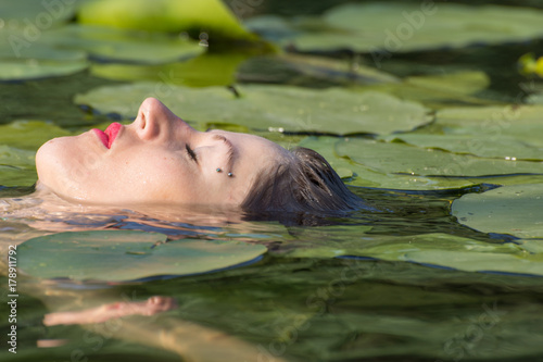 Beautiful young woman with blue eyes in the water