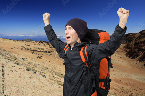 Happy man with raised arms amid the volcanic landscape of Tenerife. Teide Volcano.