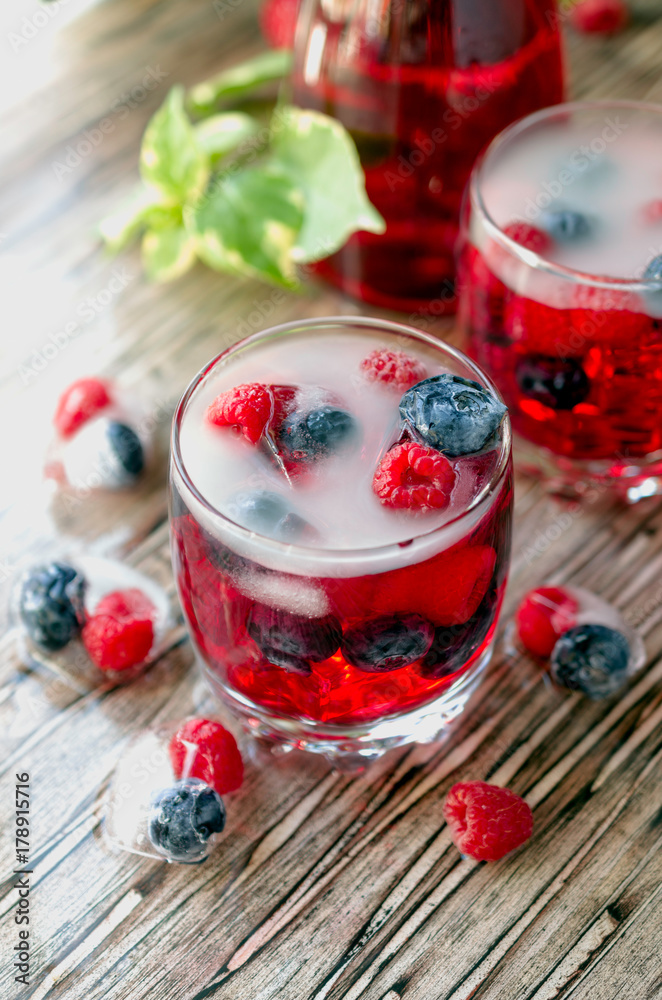 Summer berry lemonade with frozen berries on a wooden rustic table, selective focus Summer berry lemonade with frozen berries on a wooden rustic table, selective focus