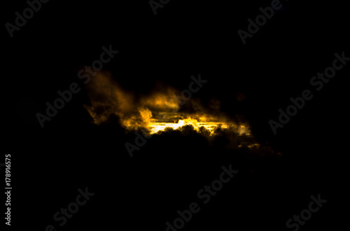 Sun rising over clouds Black background