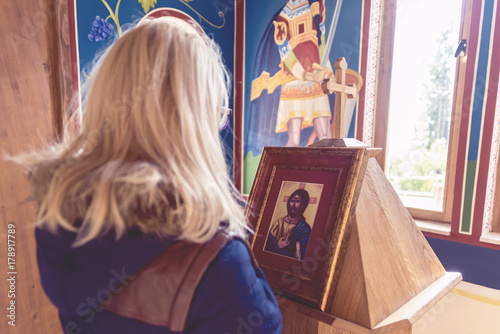 The woman prays in the church in front of the icon