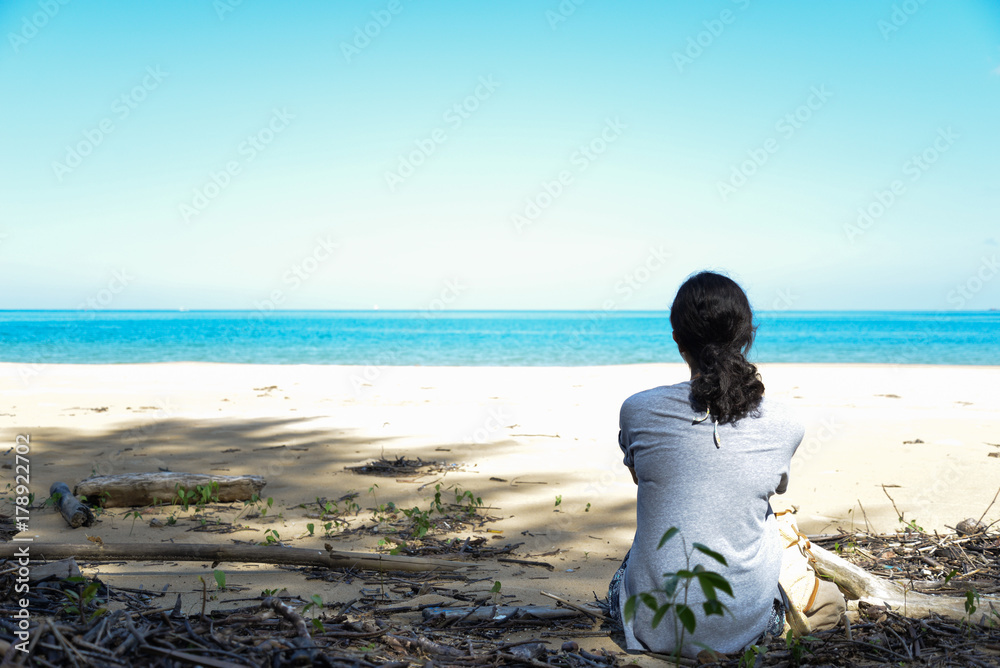 Lonely girl sitting on the beach