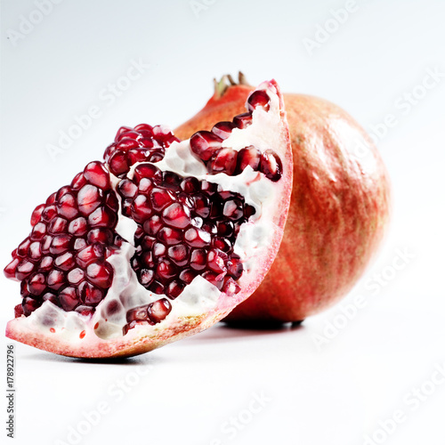 Two pomegrantes on a white  background. photo