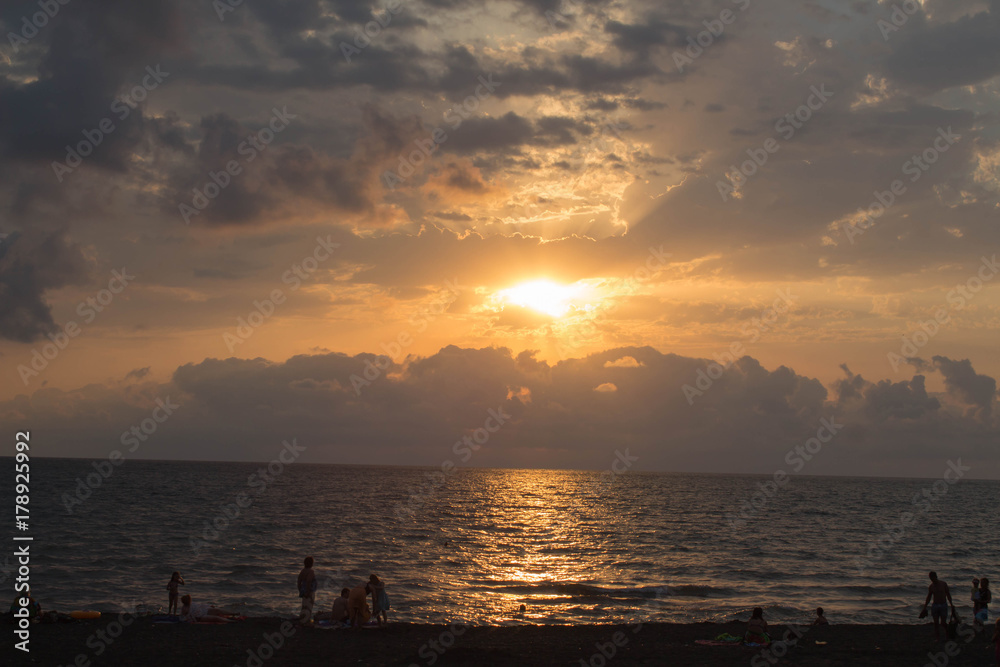 Beautiful summer golden sunset above the black sea.with calm waves and reflection of sun on the beach