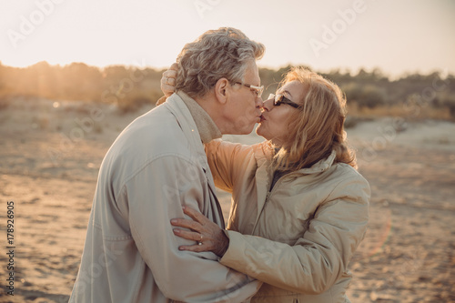 senior couple kissing on beach © LIGHTFIELD STUDIOS