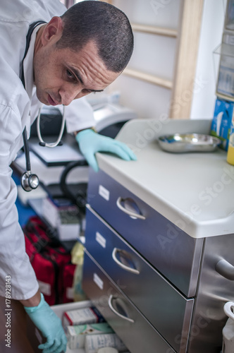 medico cerca aghi e siringhe per eseguire un'analisi del sangue in laboratorio photo