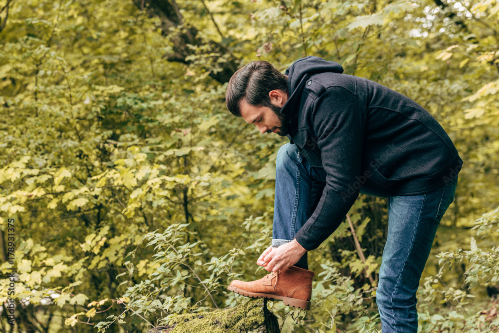 man tying shoelaces in park