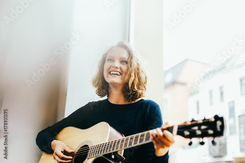 Junge blonde Sängerin spielt Gitarre