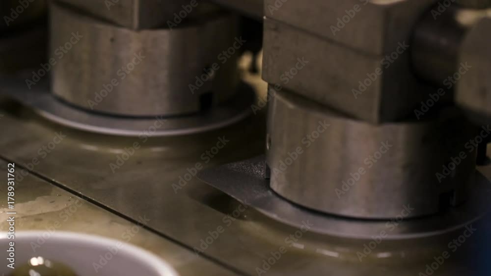 Automatic lid placement on a bucket filled with syrup in a factory Automatic lid placement on a bucket filled with syrup in a factory