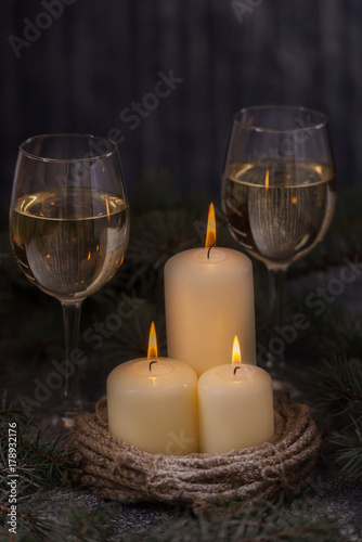 Closeup candles and glasses wine with christmas tree
