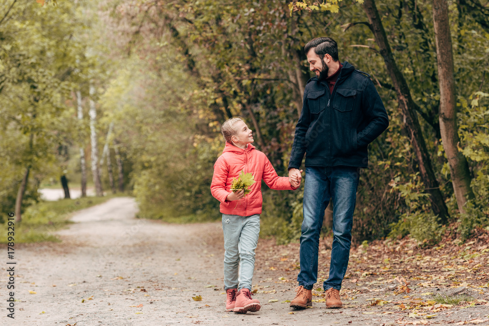 father and daughter walking in park