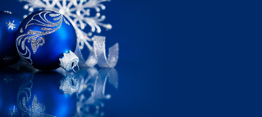 Blue christmas ornaments on blue background. Merry christmas greeting card, banner. Winter holiday xmas theme. Happy New Year.