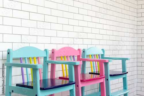 vintage child chairs on white brick wall © PRASERT