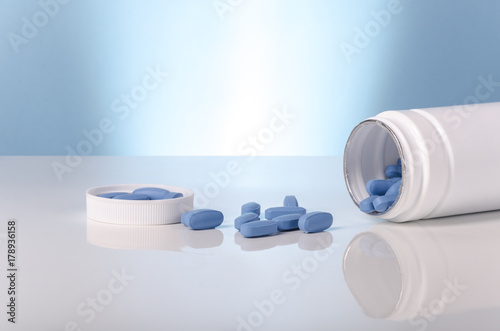 medical viagra blue tablets over white and blue background. photo