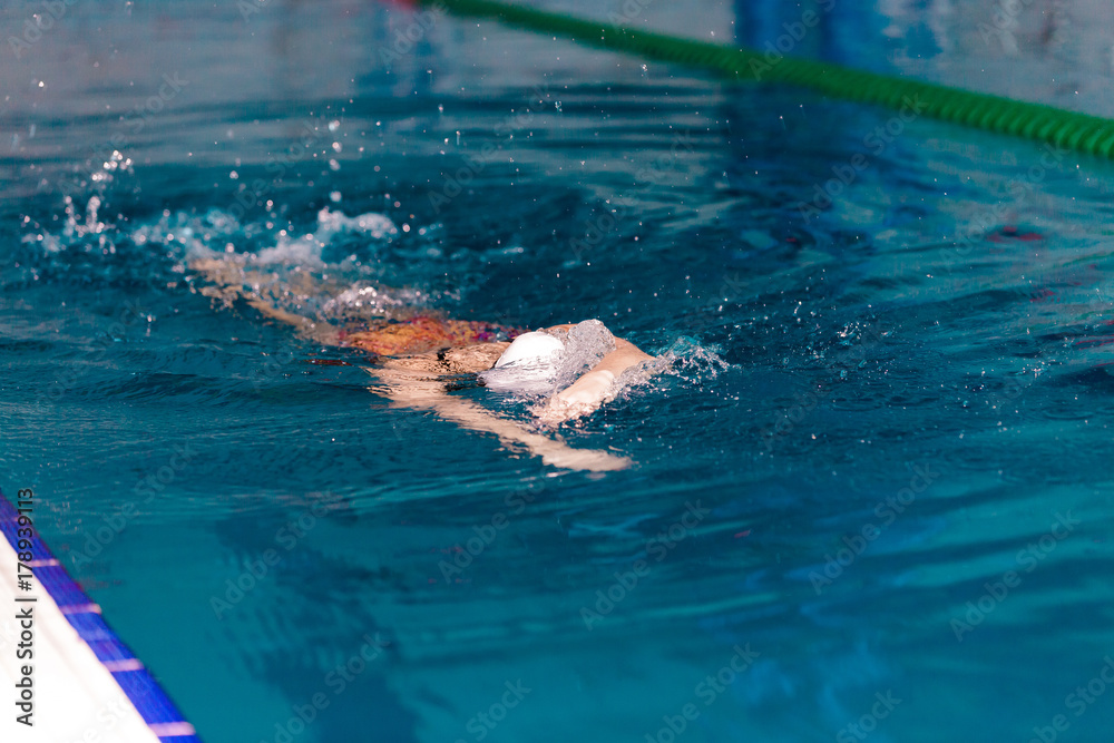 woman swimming with swimming hat in swimming pool