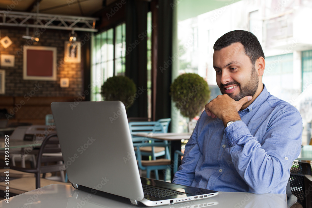 Happy handsome man looking on laptop Happy handsome man looking on laptop