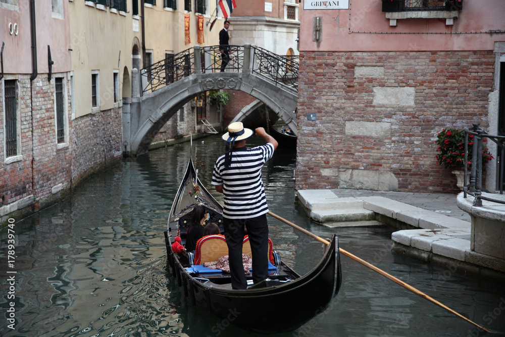 Well-uniformed condolier on a gondola, Venice