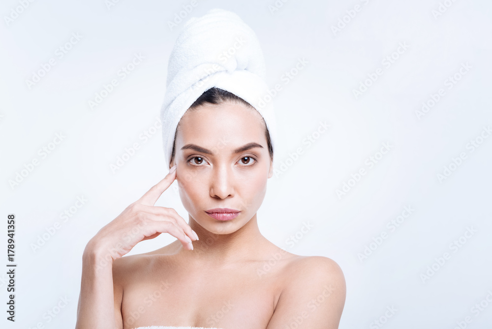 Gorgeous woman in towel turban touching her cheekbone Gorgeous woman in towel turban touching her cheekbone
