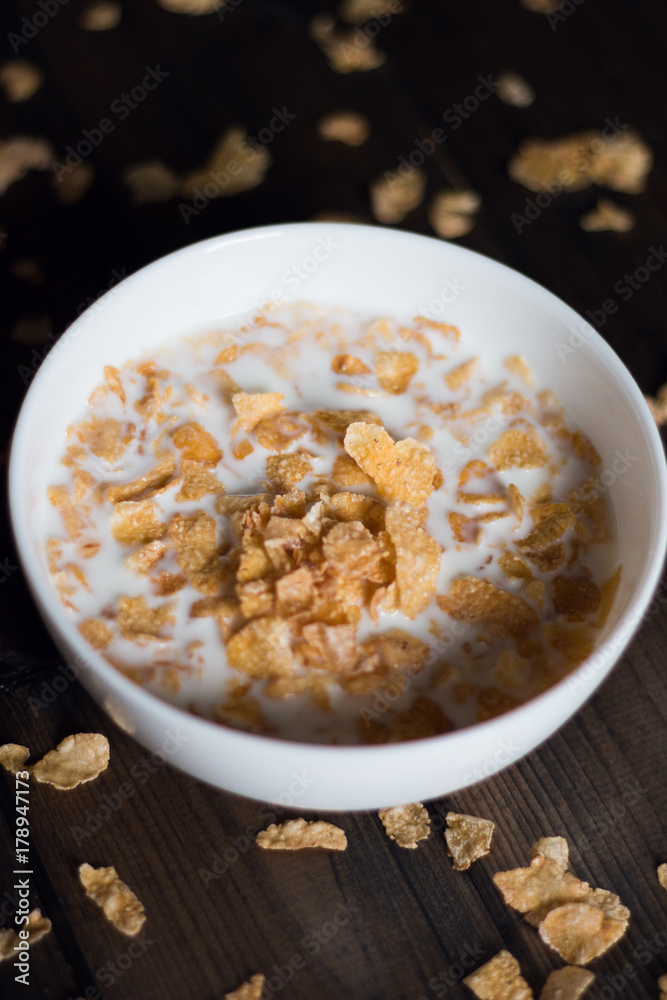 Corn flakes with milk on a wooden background Corn flakes with milk on a wooden background