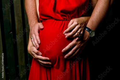 Image of pregnant woman touching her belly with hands