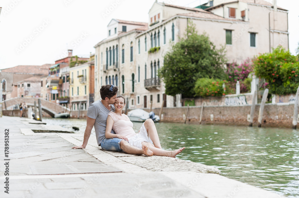 Italy, Venice, couple in love relaxing at canal