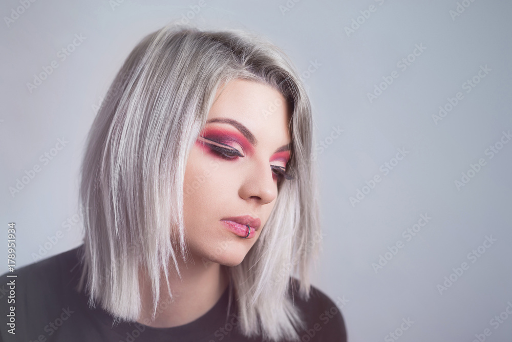Beautiful young woman with red makeup