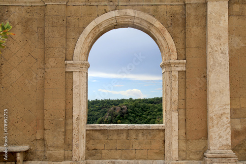 Italian view through the arch window in Sorano, Tuscany, Italy.