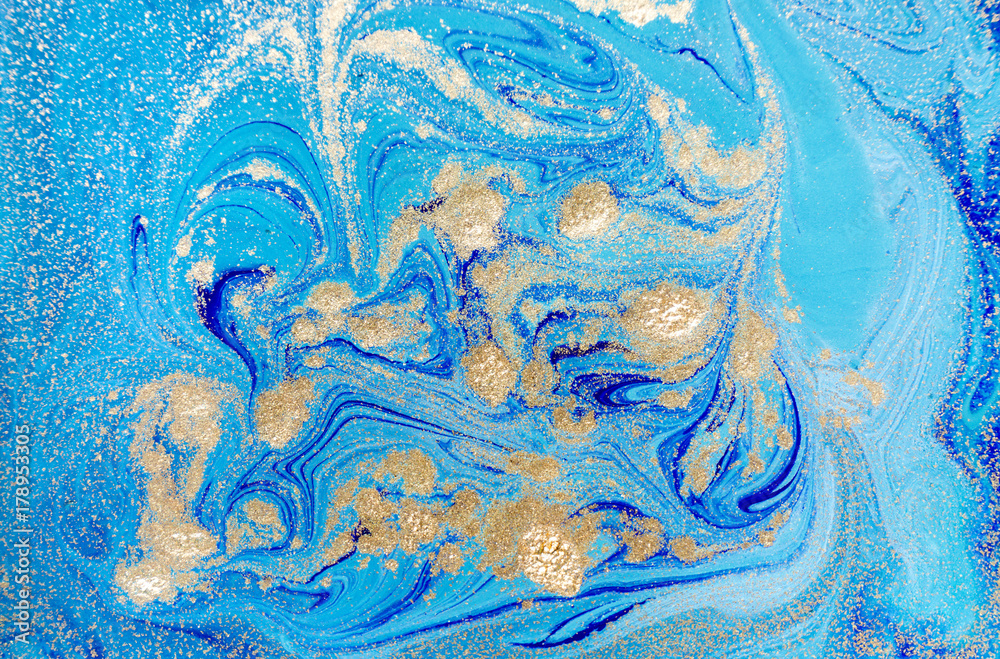 Fototapeta premium Marbled blue abstract background with golden sequins. Liquid marble ink pattern.