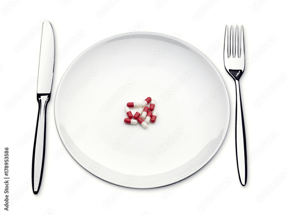 pills on an empty plate with knife and fork pills on an empty plate with knife and fork