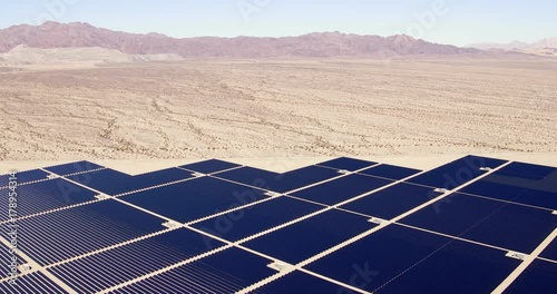 Aerial view flying over large solar farm in desert creating clean renewable energy 