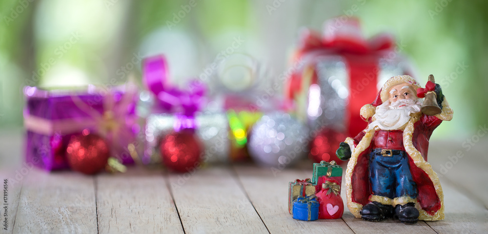 Santa Claus and gift box with blurred background in Christmas and New year day on wooden table