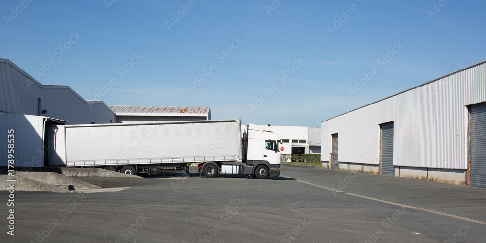 Unloading cargo from truck at an entrance of warehouse
