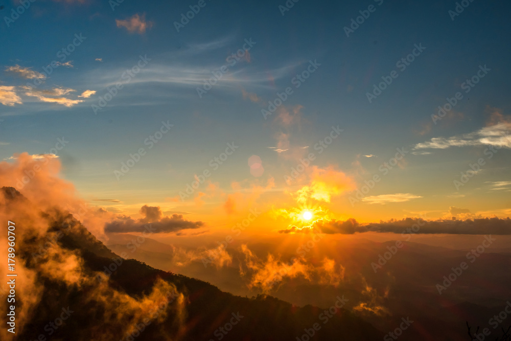 Beautiful mountain sky and clouds with golden light at sunset. subject is blurred.
