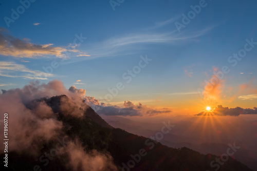 Beautiful mountain sky and clouds with golden light at sunset. subject is blurred.