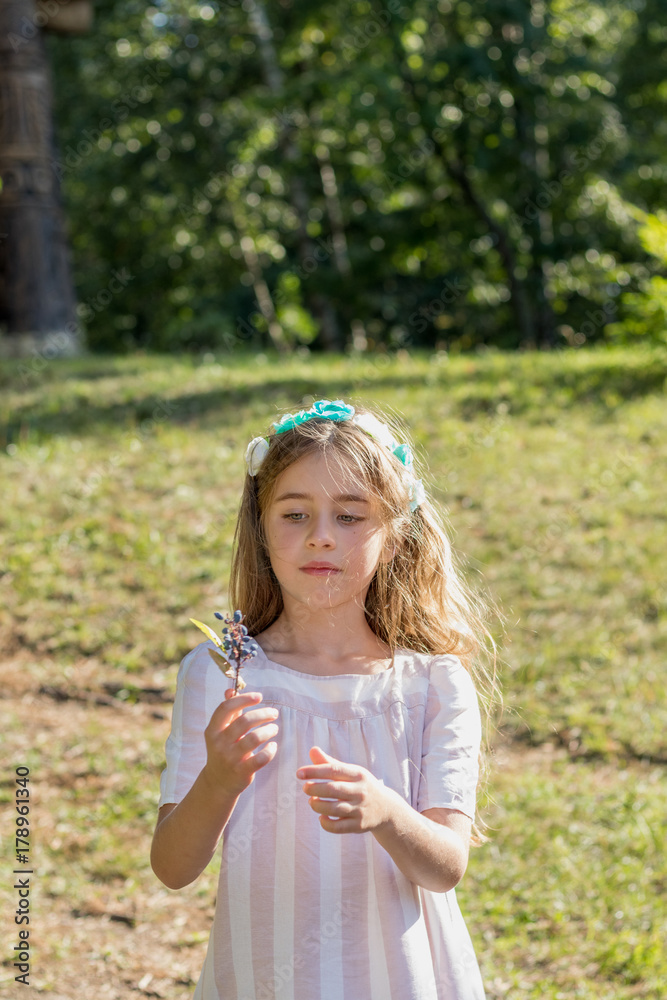 Cute little girl walking in the city park on a sunny summer day Cute little girl walking in the city park on a sunny summer day