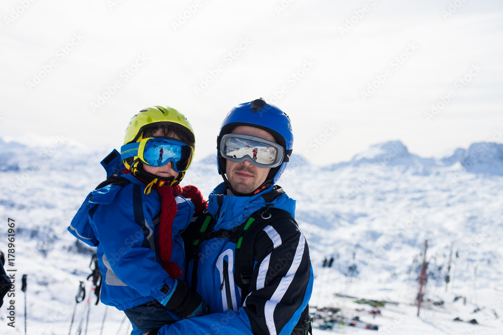 Father and son, skiing happily in Austrian ski resort in the mountains Father and son, skiing happily in Austrian ski resort in the mountains