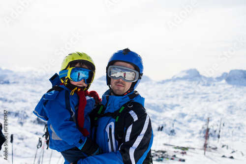 Father and son, skiing happily in Austrian ski resort in the mountains