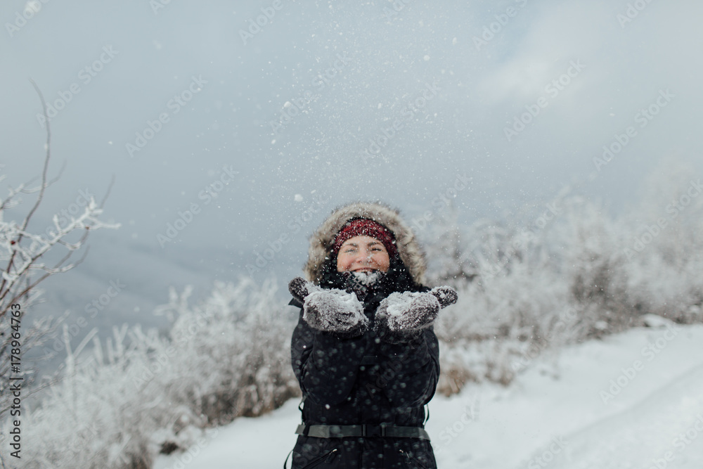 Smiling woman dressed warm enjoying a snowy day outside Smiling woman dressed warm enjoying a snowy day outside