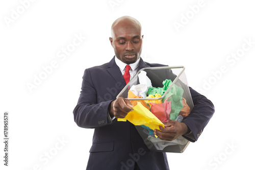 Portrait of African businessman searching document among crumpled papers in paper basket