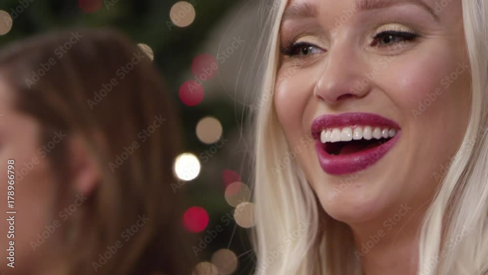 Close up handheld shot of a woman talking and smiling while eating dessert at a holiday party Close up handheld shot of a woman talking and smiling while eating dessert at a holiday party