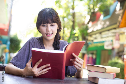 Portrait of Happy Woman reading book. Asian women reading books with attractive smiling emotions, Woman with eduction Concept.