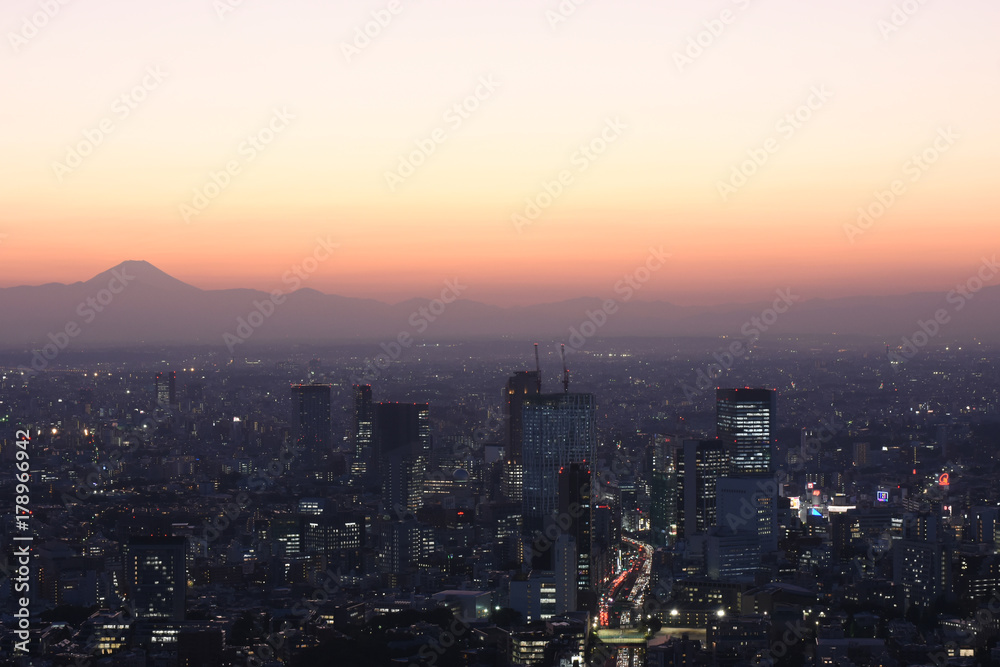 日本の東京都市景観・都心から望む富士山。太陽が沈んだあともシルェツトが浮かび上がった（手前は、渋谷のビル群など）