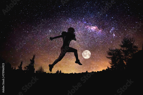 player football man jumping at the night starry sky background. Mixed media