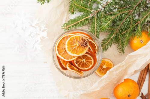 Dried oranges in the bowl with tangerines and fir twigs