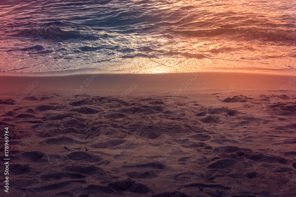 Many various footprint on sand beach with sunset light reflect on sea surface in twilight time. (Delective focus) Many various footprint on sand beach with sunset light reflect on sea surface in twilight time. (Delective focus)