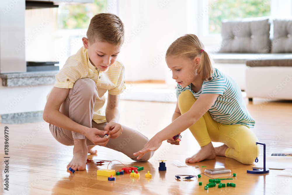 Fototapeta premium Two curious happy children playing with game