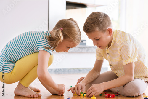 Two curious happy children playing with game